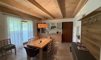 A bright living room with a dining area and a modern kitchen. Large windows ensure plenty of daylight and a cozy atmosphere.