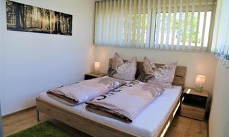 A cozy bedroom with a large bed and soft pillows.  
Large windows provide plenty of daylight and a relaxing atmosphere.