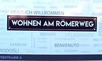 A welcome sign with the text "Living on Römerweg". Surrounded by various greetings in multiple languages.