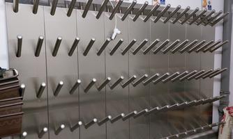 A modern wall with multiple stainless steel holders for items. It showcases a tidy and functional arrangement.