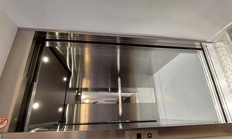 A modern elevator with stainless steel walls and good lighting. The interior is clean and inviting.