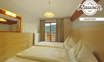 A bright room with two single beds and large windows that overlook a beautiful view. The decor is modern and inviting.