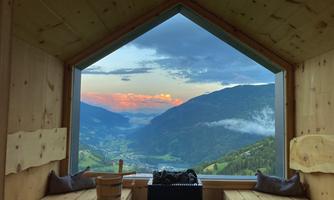 A beautiful view from a wooden room of the mountains and the valley. The evening twilight creates a warm atmosphere.