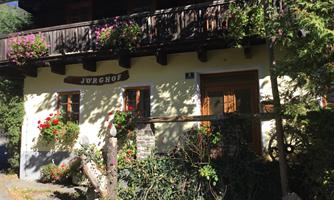 A charming house with blooming plants and a balcony. The sunny facade radiates an inviting atmosphere.