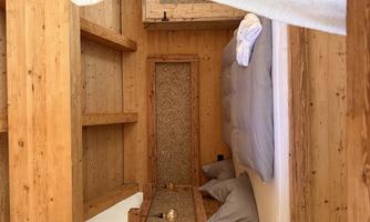 A cozy room with wooden walls and a comfortable bed. The decor is simple and inviting, perfect for relaxation.