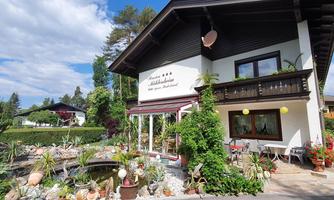 A charming house with a well-maintained garden and blooming plants. The surroundings are green and inviting, ideal for relaxing moments.