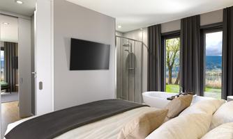 A modern bedroom with a large bed, a television, and an elegant bathroom area. Large windows let in plenty of light and offer a view of the outdoors.