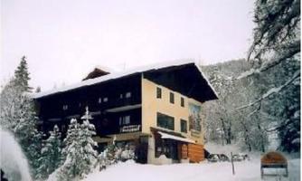 A cozy house in the snow, surrounded by snow-covered trees. The winter landscape creates a peaceful atmosphere.