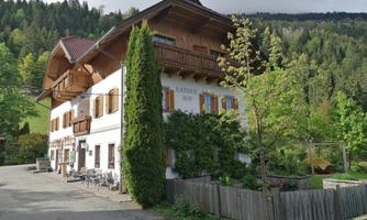 A charming country house with wooden windows and a green garden. Surrounded by trees and a picturesque landscape.