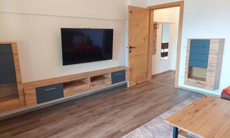 The living room has a large television on the wall.
