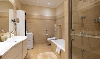 A modern bathroom with a bathtub and a shower cubicle. The walls are in a light tone, and the room feels clean and inviting.