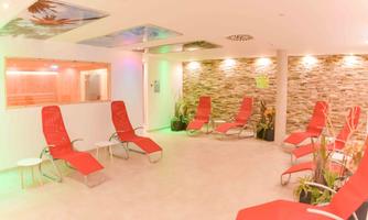A relaxing room with red loungers and a modern atmosphere. Soft lighting and decorative elements provide well-being.