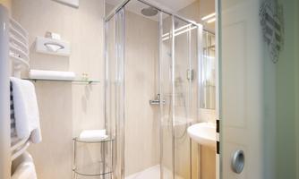 A modern bathroom with a glass shower and a sink. Clean towels and a bright, inviting atmosphere.
