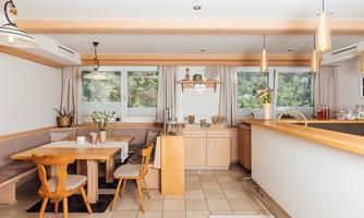 A cozy dining area with a wooden table and chairs. The decorative kitchen offers an inviting and bright space.