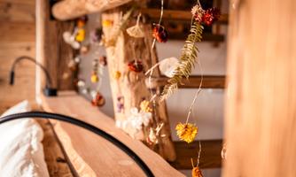 A cozy interior with wooden structures and dried flowers gently hanging. The warm atmosphere invites relaxation.