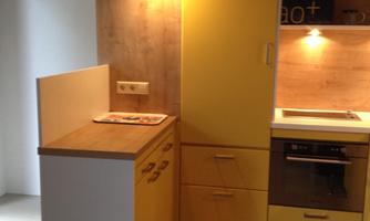 A modern kitchen with yellow and white cabinets. The furnishings are designed to be bright and functional, ideal for cozy cooking.
