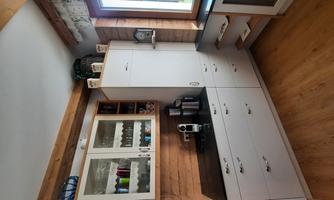 A modern kitchen with white cabinets and a black workspace. The window offers a view of the outside and lets in plenty of light.