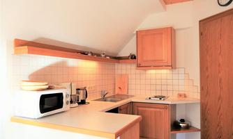 A cozy kitchen with wooden cabinets and modern appliances. The bright atmosphere creates an inviting ambiance.