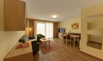 A cozy living and dining room with modern furniture. Large windows provide plenty of natural light.
