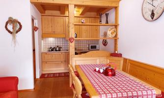 A cozy kitchen with a dining table and wooden details. The space is bright and inviting, with modern amenities.
