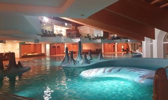 A modern indoor pool with colorful water attractions. The atmosphere is relaxed and inviting.