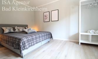 A cozy bedroom with a large bed and beautiful bedding. Two pictures hang on the wall, and there is a wardrobe next to the bed.