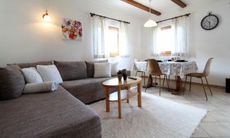 An inviting living room with a cozy sofa and a small table. The room has bright windows and a modern decor.