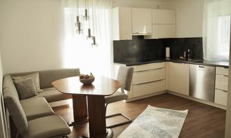 Modern kitchen with a cozy dining area. Bright colors and elegant furniture create an inviting atmosphere.