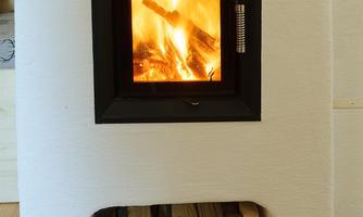 A modern fireplace with flickering flames and logs underneath. The warm flame creates a cozy atmosphere.