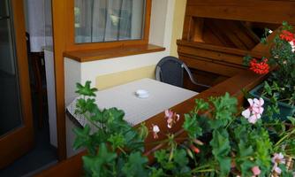 A cozy balcony with a table and a chair. Colorful flowers and a relaxed atmosphere create an inviting spot to linger.