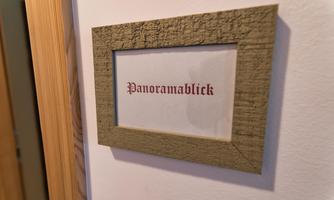 A picture frame on a wall with the text "Panoramic View." The frame has a textured surface in neutral colors.