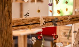 A cozy interior with a wooden structure. Colorful dried flowers hang decoratively between the posts.