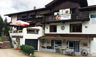 A cozy restaurant with a balcony and outdoor seating. The facade is traditionally decorated with loving details.