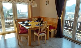 A cozy dining area with a wooden table and chairs. Large windows provide a beautiful view and plenty of natural light.