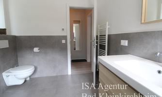 A modern bathroom with bright walls and an elegant sink. It features a shower and a toilet in stylish design.