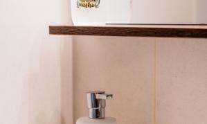 An elegant soap dispenser stands on a shelf. Above it is a decorative glass with the inscription "Good Morning Sunshine."