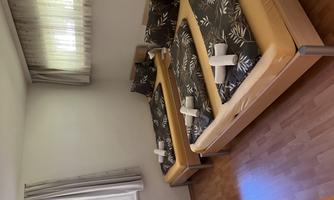 A cozy room with three single beds and attractive bedding. There is plenty of daylight through the window and the walls are bright.