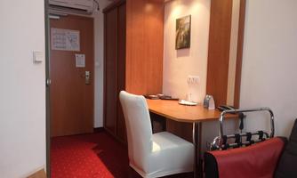 A cozy room with a desk and a chair. The walls are made of wood, and there is a door to another room.
