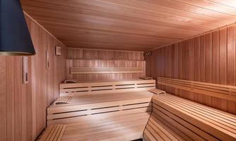 A Finnish sauna with wooden paneling and benches. The room radiates warmth and relaxation.