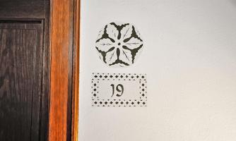 A stylish door sign with the number 19. Below it is a decorative pattern.