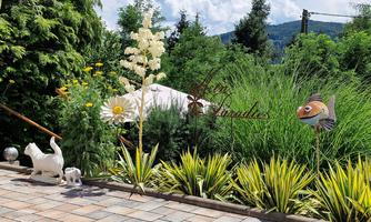 A beautiful garden with decorative plants and figures. In the background, a sunny sky and a shady spot can be seen.