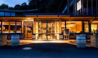 A modern restaurant with large windows and warm light. The atmosphere is stylish and inviting.
