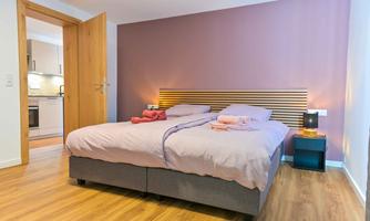 A modern bedroom with two single beds and a cozy atmosphere. The walls are painted in soft colors and the room is well-lit.