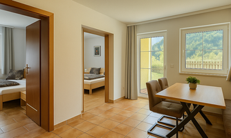 A bright and modern room with tiled flooring. There is a dining area with a table and chairs as well as two adjoining bedrooms.