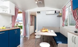 A modern, bright accommodation with a kitchenette and a dining table. The rooms are cheerfully decorated and offer a cozy seating area.