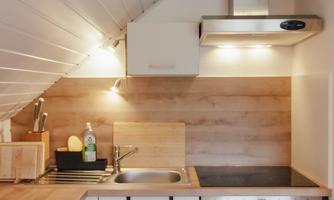 A modern kitchen with wooden surfaces and a cooking area. It is well-equipped and has a friendly atmosphere.