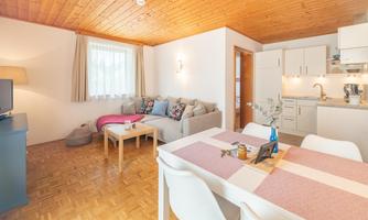 A bright, modern apartment with a cozy living room and an open kitchen. The space is decorated in a friendly way and invites relaxation.