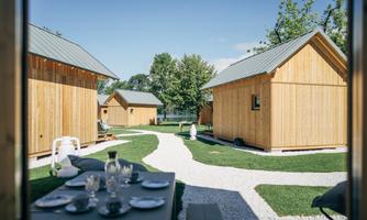 A picturesque garden with several wooden houses. The well-kept lawn and the beautiful paths create an inviting atmosphere.