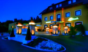 A beautiful building with a yellow facade, illuminated by orange lights. The entrance area is decorated with lanterns and green plants.