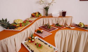 A beautifully set table with various fruit platters and treats. The decoration is colorful and inviting.